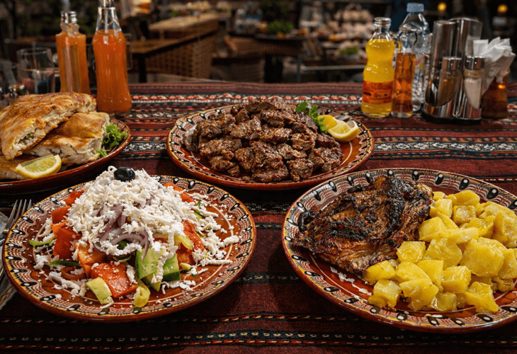 Sofya’da bir restoranda servis edilen shopska salata, ızgara et ve patates – Bulgar mutfağı